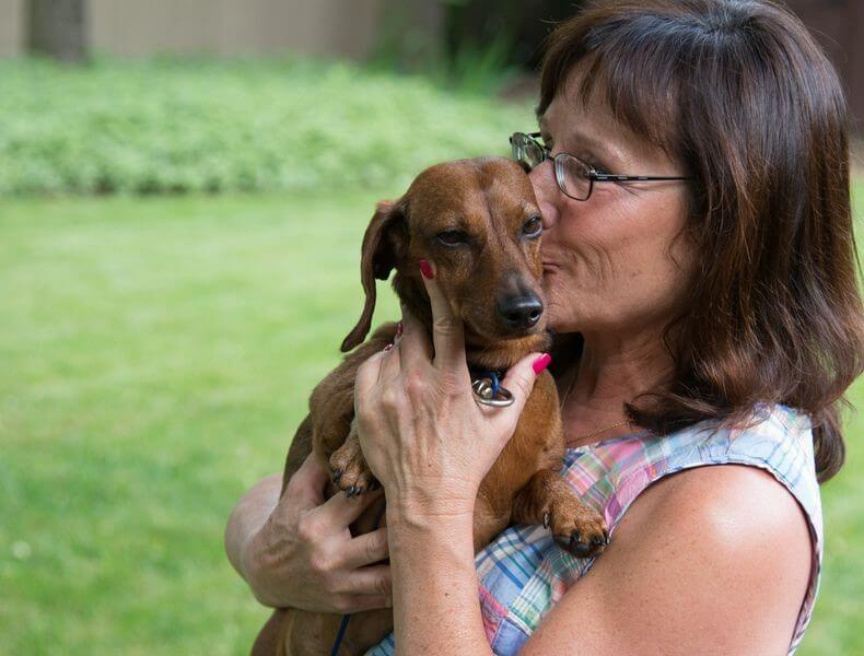 Woman kissing her dog